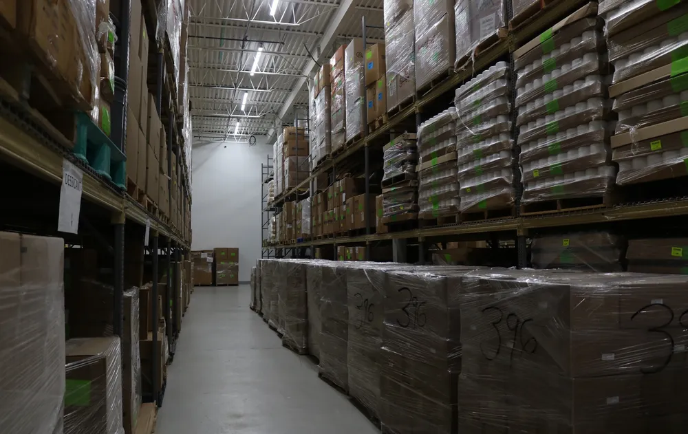 Spacious warehouse with neatly stacked boxes and shelves at Advanced Supplements