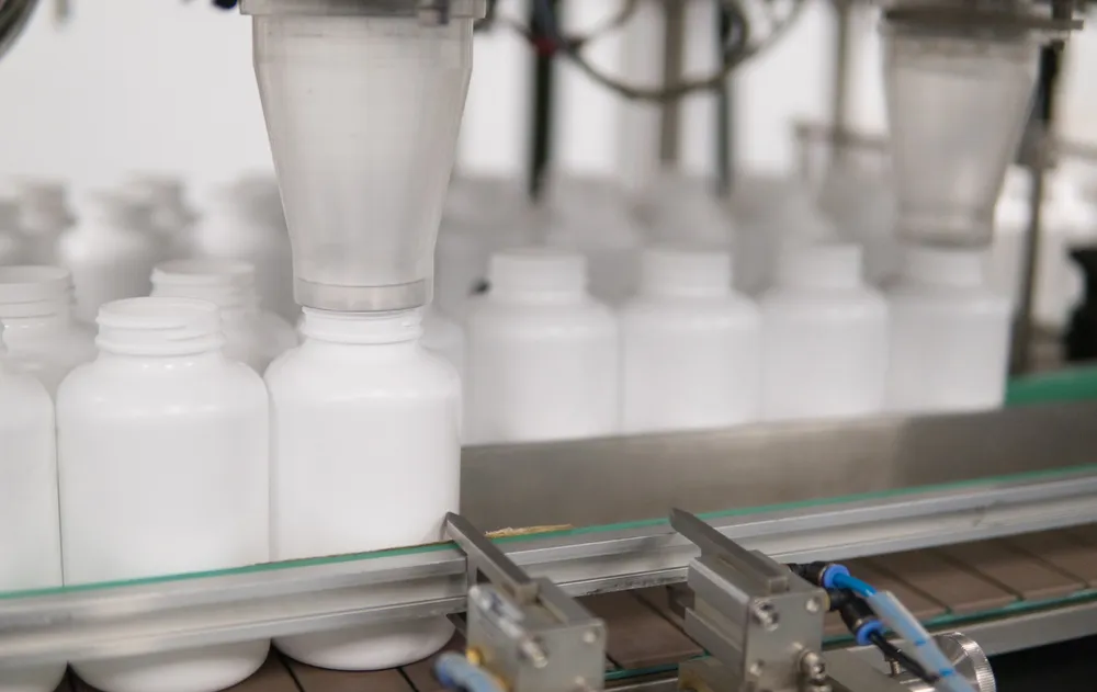 Machine filling bottles, showcasing advanced supplement manufacturing technology